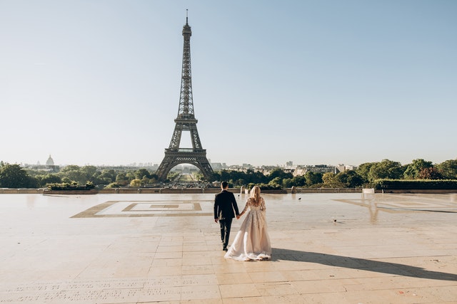 Brautpaar spaziert im Park vor Eiffelturm in Paris