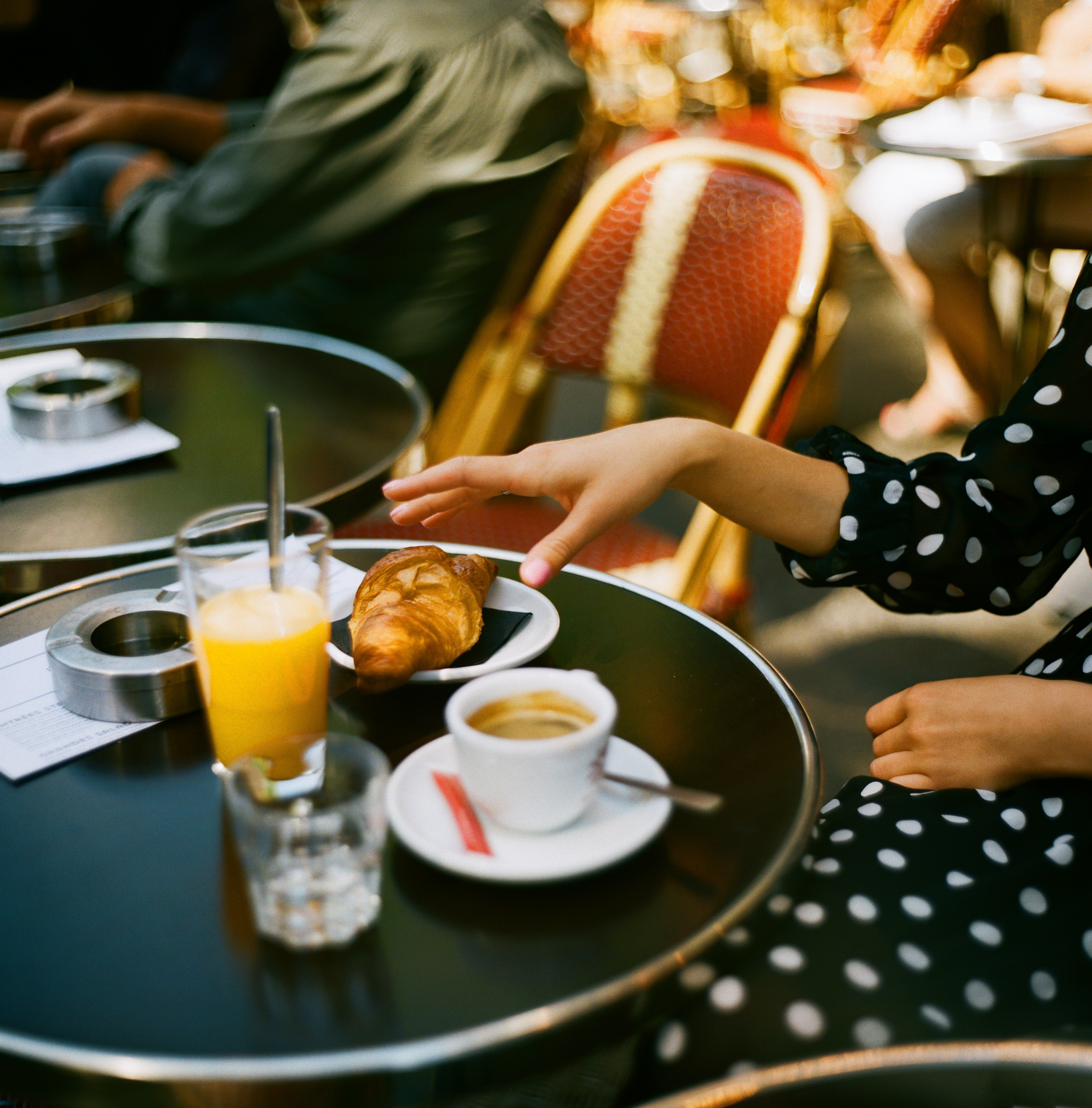 Eine Frau geniesst ihr Frühstück in einem Pariser Cafe