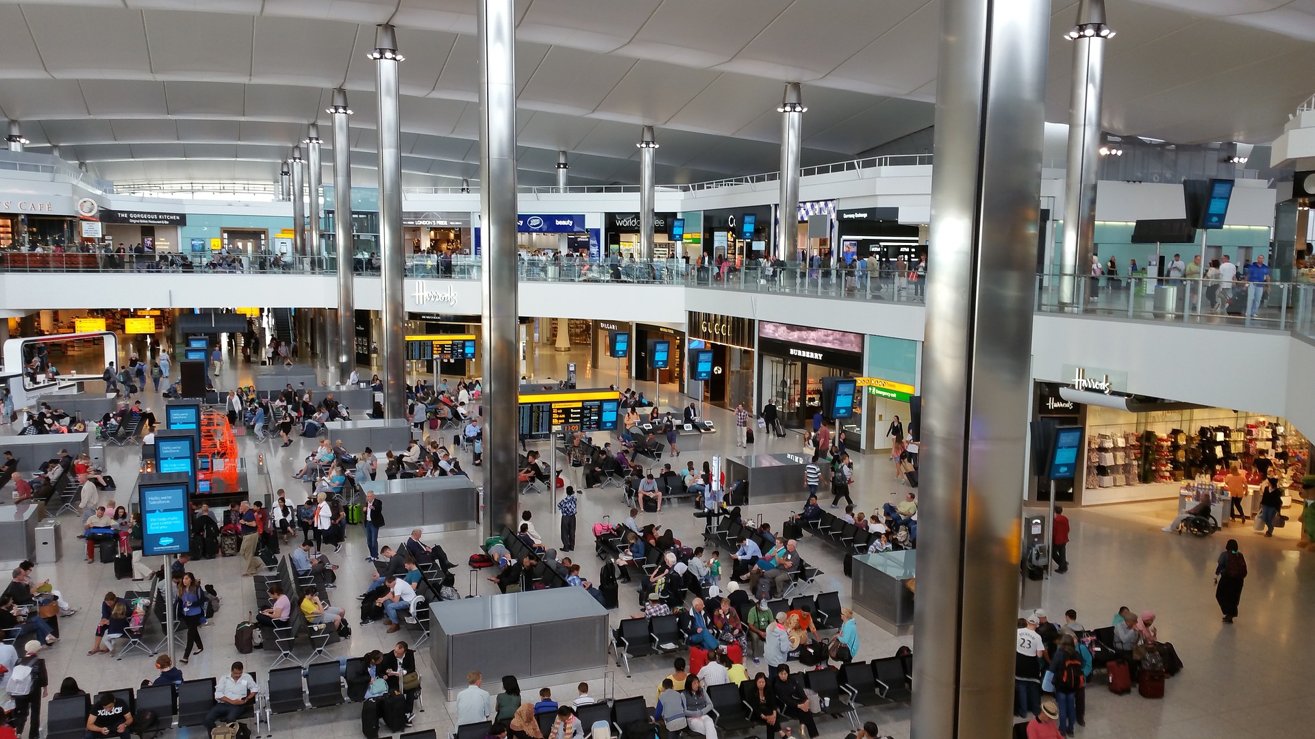Reisende in der Wartehalle eines Terminals am Flughafen London Heathrow