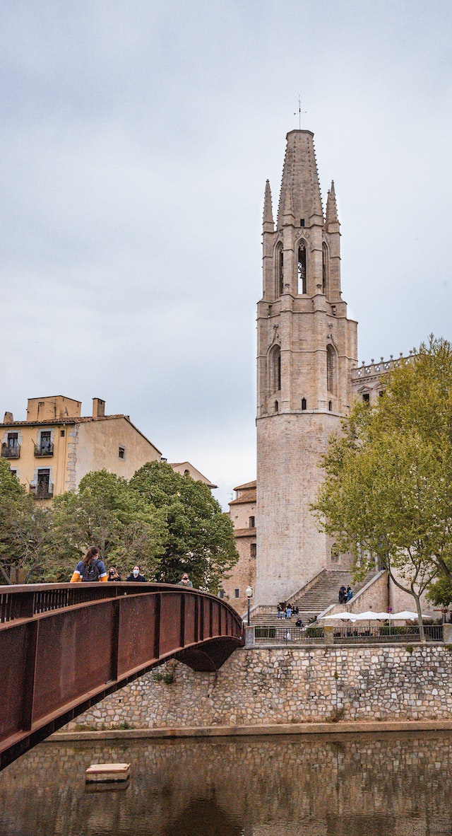Menschen spazieren ueber die Bruecken der Stadt Gironas