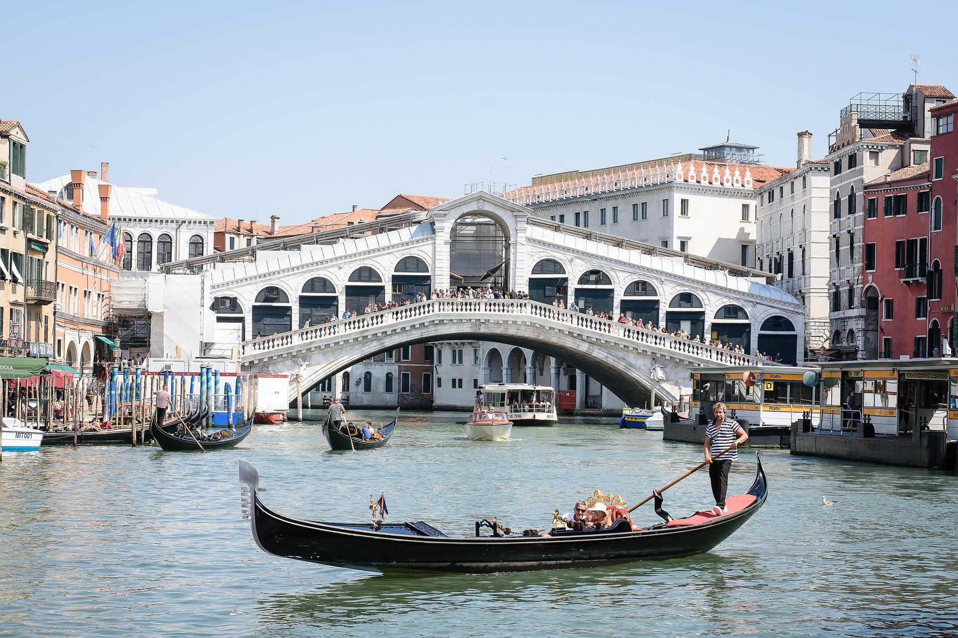 Ein Gondolier vor der Rialtobruecke in Venedig