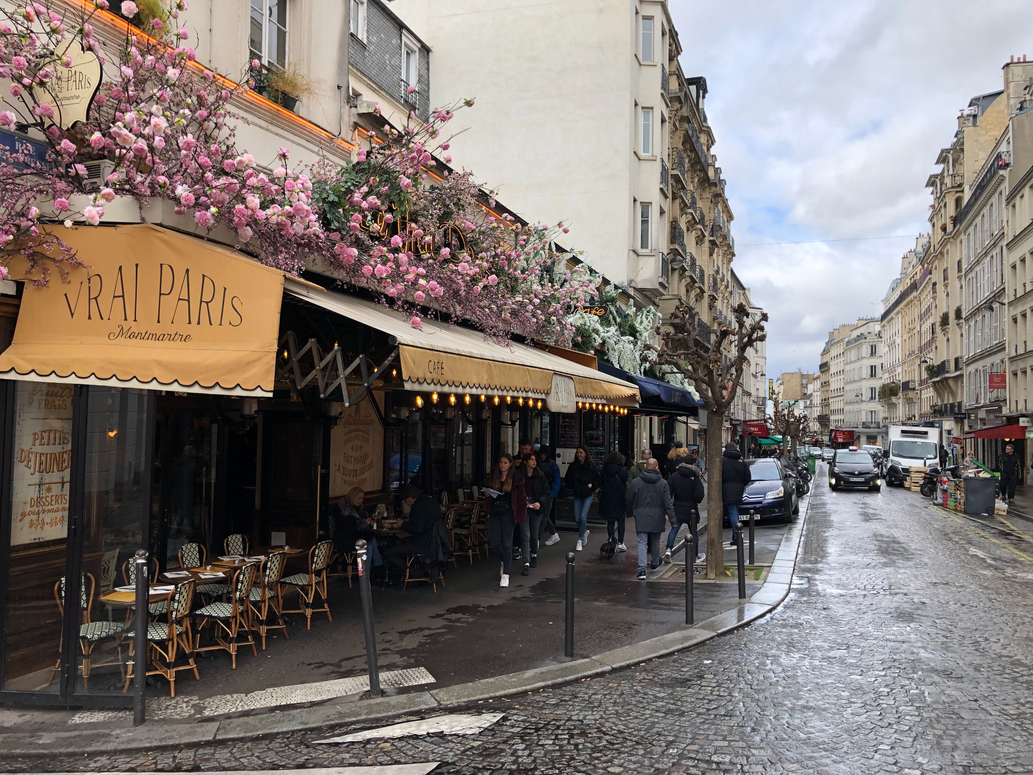 Strassencafe an Kopfsteinpflaster Strasse in Paris im Fruhling