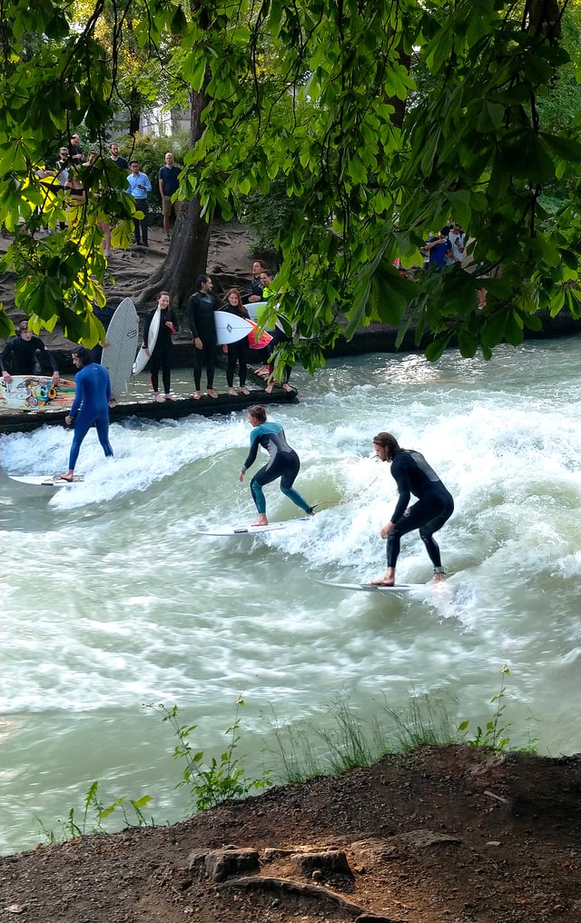 Surfer boarden auf der Eisbachwelle im Englischen Garten in Munchen