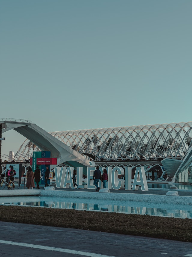 Touristen spazieren vor dem Valencia Zeichen