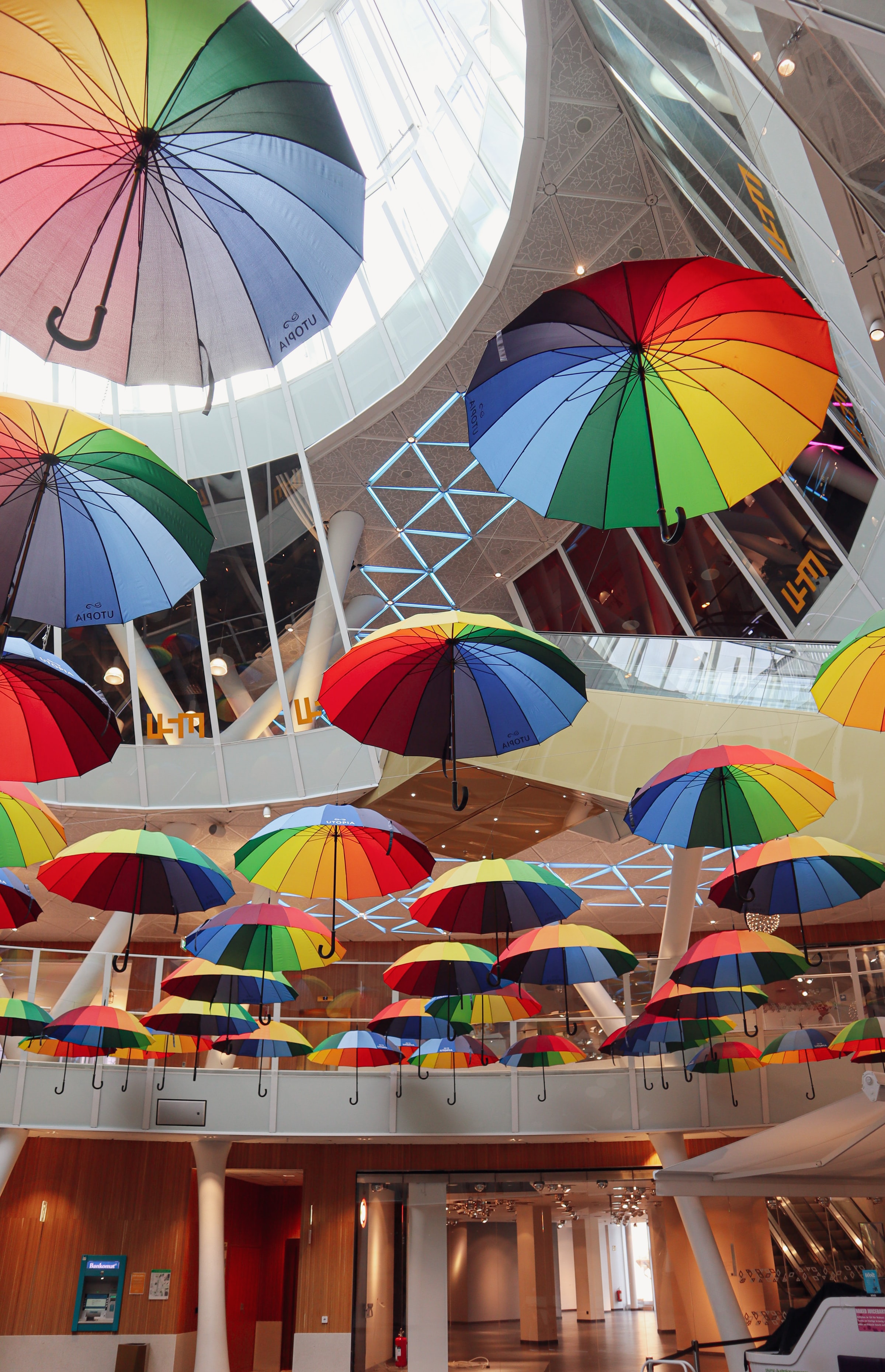 Färgglada paraplyer som hänger i tak.