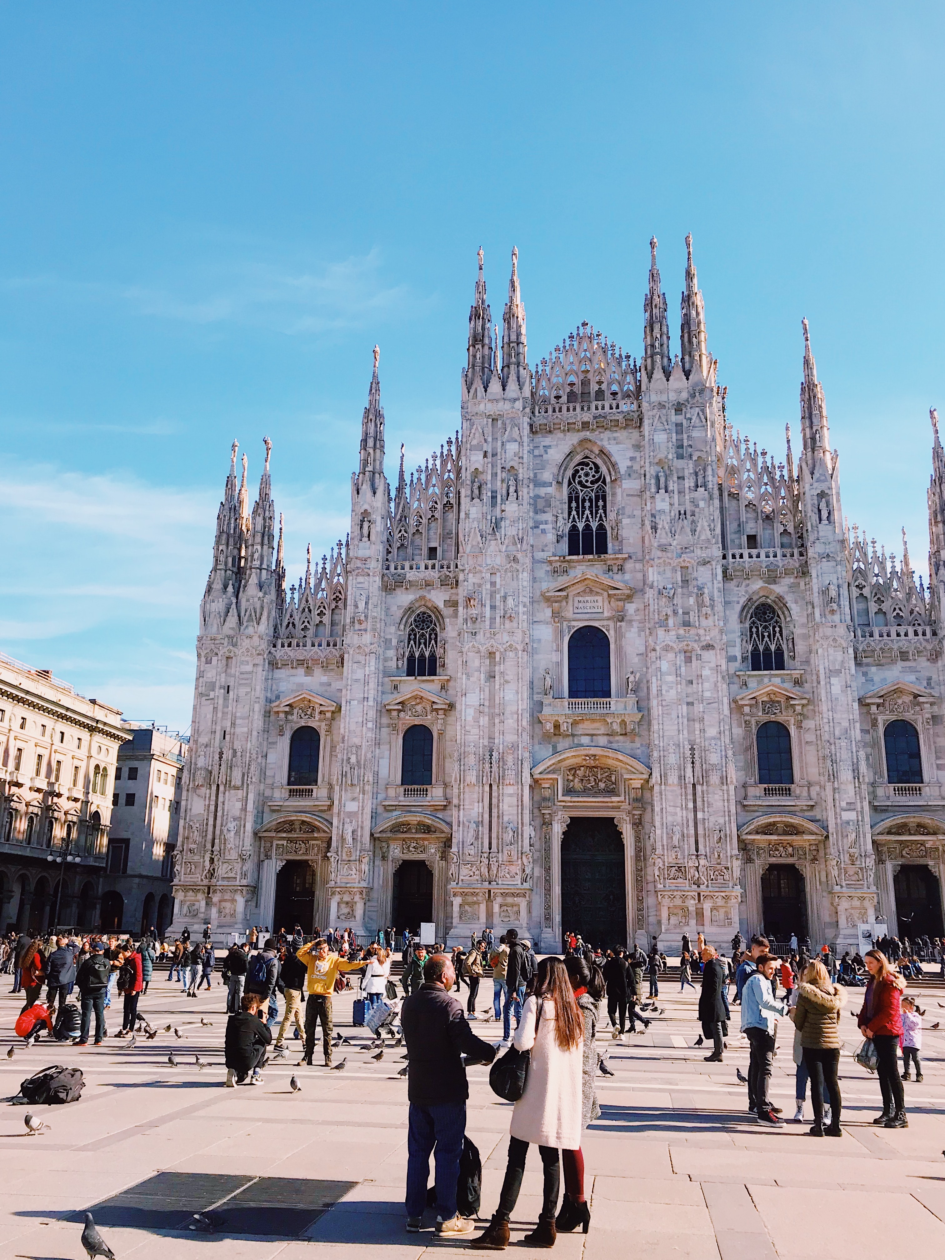Turistas visitando la Catedral de Milan de estilo gotico