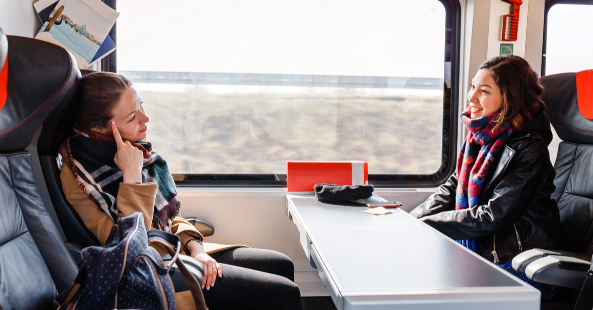 Travel from Leeds city centre to Leeds train station: friends chatting on a train